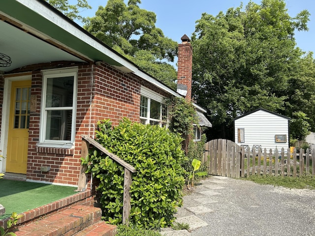 2204 Dover St, North Charleston, SC 29405 - view of side of property featuring brick siding, a chimney, and a gate
