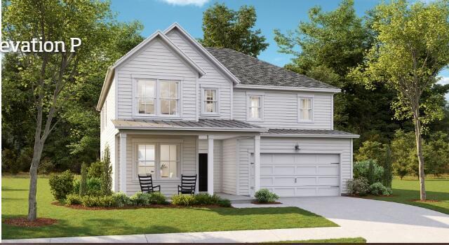 traditional home featuring a garage, driveway, and a front lawn