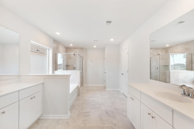 bathroom with visible vents, two vanities, a sink, a shower stall, and a bath