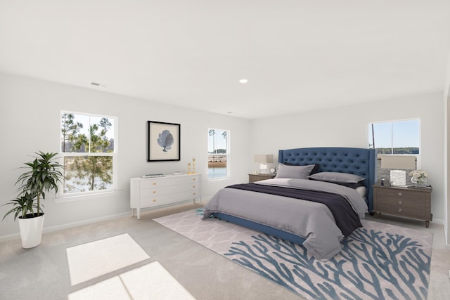 carpeted bedroom with multiple windows, visible vents, and baseboards