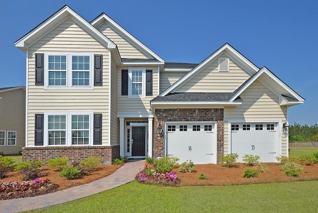 view of front facade with a shingled roof, a front yard, brick siding, and an attached garage