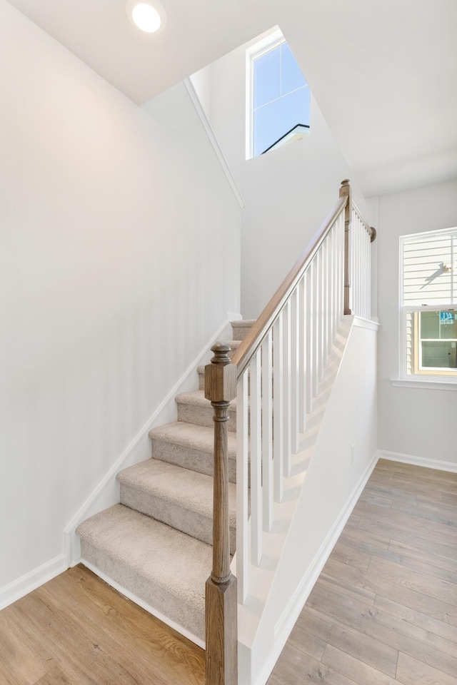 stairway with recessed lighting, baseboards, and wood finished floors