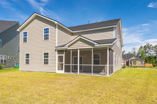 rear view of property featuring a yard, a shingled roof, and a sunroom