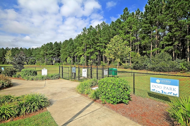 view of home's community with a gate, fence, and a lawn