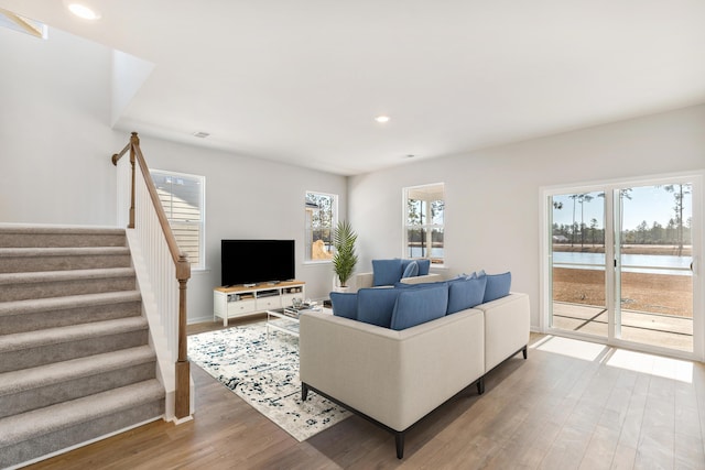 living area with stairs, wood finished floors, and recessed lighting