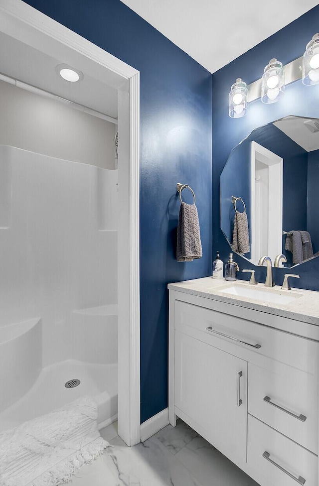 full bath featuring walk in shower, marble finish floor, and vanity