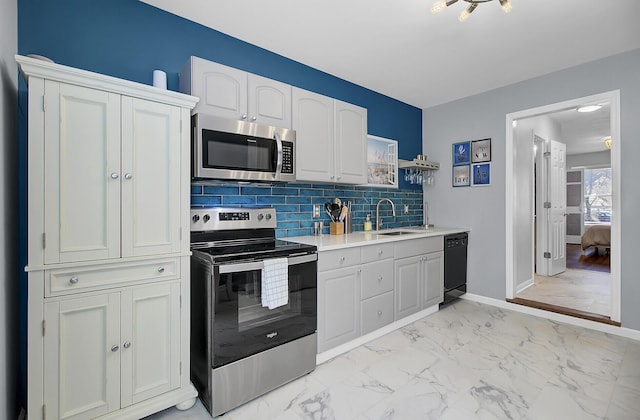 kitchen with a sink, marble finish floor, appliances with stainless steel finishes, and white cabinetry