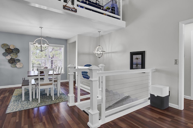 stairs featuring baseboards, an inviting chandelier, and wood finished floors