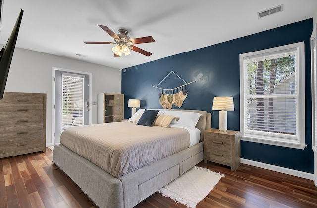 bedroom with wood finished floors, visible vents, and baseboards