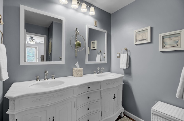 full bathroom with double vanity, baseboards, and a sink