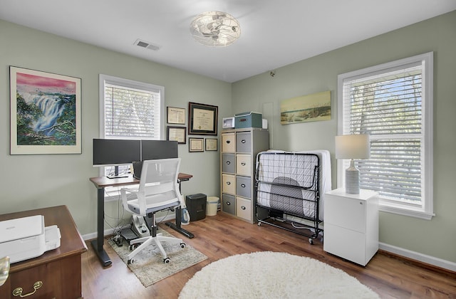 office space featuring visible vents, baseboards, and wood finished floors