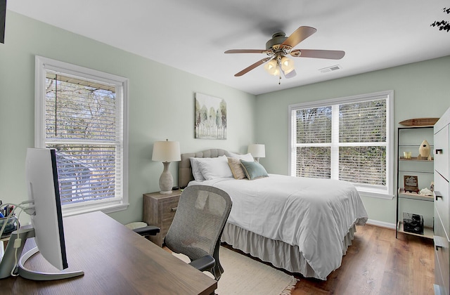 bedroom featuring visible vents, baseboards, ceiling fan, and wood finished floors