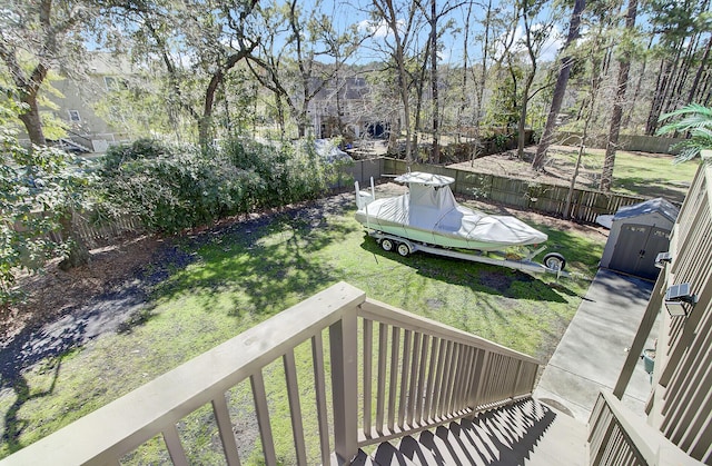 view of yard featuring a storage unit, a fenced backyard, and an outdoor structure