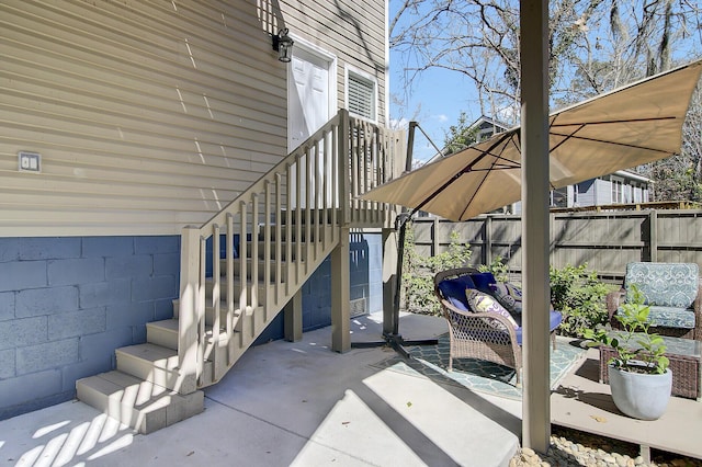 view of patio featuring stairway and fence