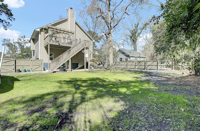 view of yard featuring a deck, a fenced backyard, stairs, and a gate