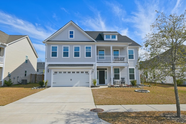 view of front of house with covered porch, driveway, a front yard, and a balcony