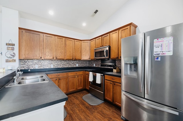 405 Watershed Dr, Goose Creek, SC 29445 - kitchen with appliances with stainless steel finishes, a sink, lofted ceiling, dark countertops, and brown cabinets
