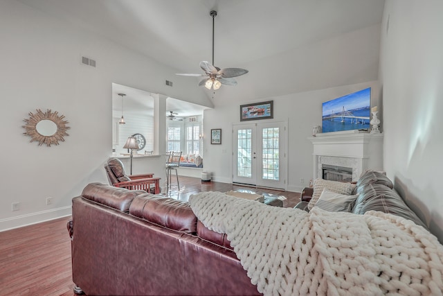 living room with french doors, ceiling fan, wood-type flooring, and vaulted ceiling