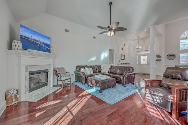 living room with hardwood / wood-style flooring, ceiling fan, high vaulted ceiling, a fireplace, and ornate columns