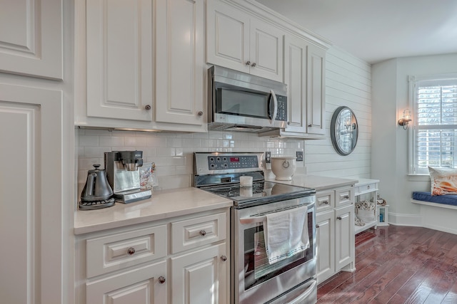 kitchen featuring white cabinetry, appliances with stainless steel finishes, dark hardwood / wood-style floors, and decorative backsplash