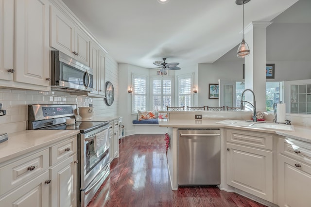 kitchen with sink, white cabinets, dark hardwood / wood-style flooring, decorative backsplash, and stainless steel appliances