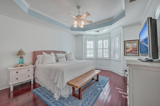 bedroom with dark hardwood / wood-style flooring, a tray ceiling, and ornamental molding