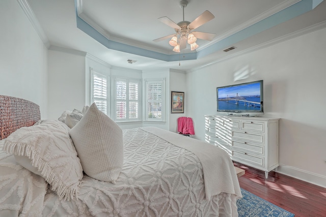 bedroom featuring hardwood / wood-style flooring, crown molding, ceiling fan, and a tray ceiling