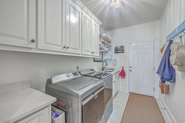 clothes washing area with cabinets, washer and dryer, sink, and light tile patterned floors