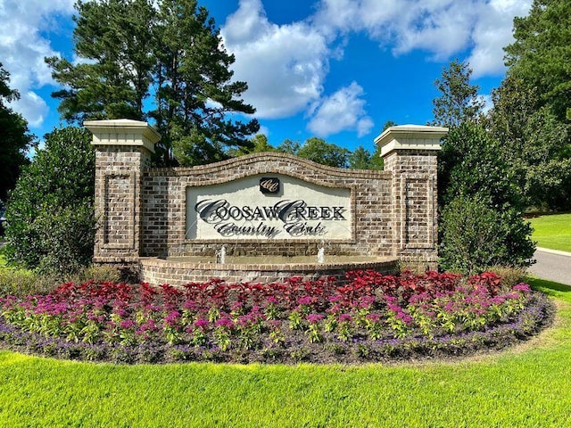 community / neighborhood sign featuring a lawn