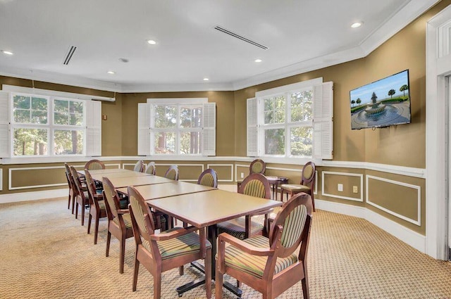 carpeted dining space featuring crown molding