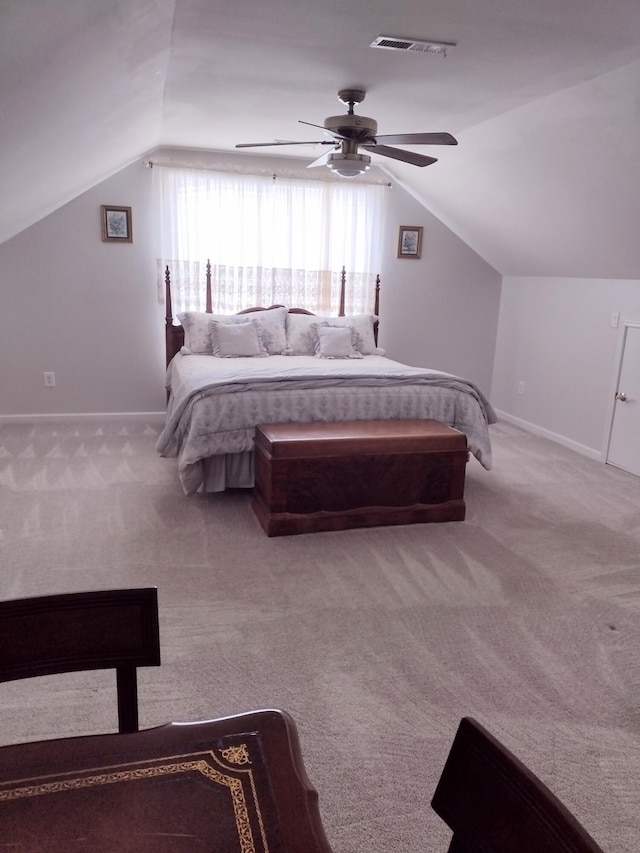 carpeted bedroom featuring baseboards, lofted ceiling, visible vents, and ceiling fan