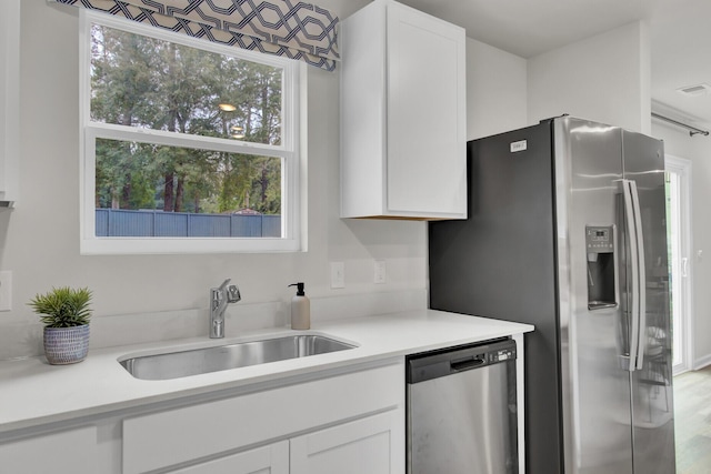 kitchen featuring white cabinets, stainless steel dishwasher, and sink