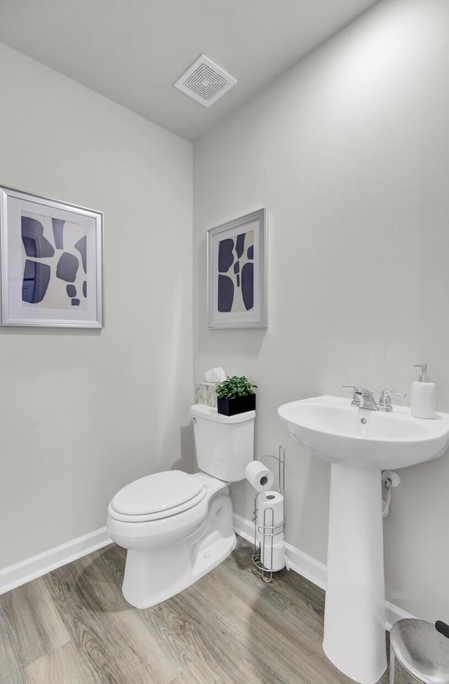 bathroom featuring toilet, hardwood / wood-style flooring, and sink