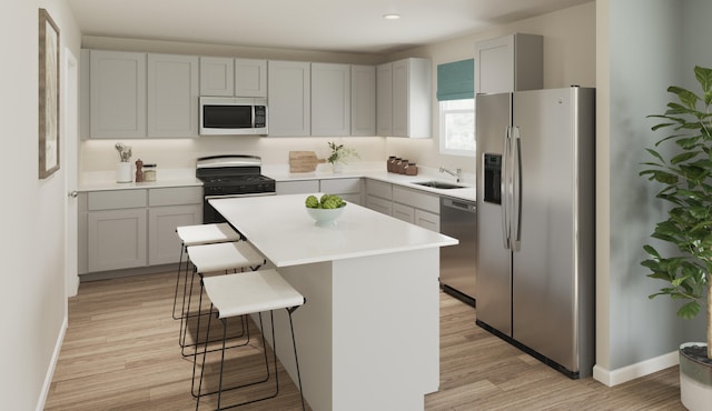 kitchen with light hardwood / wood-style flooring, a center island, stainless steel appliances, a breakfast bar area, and sink