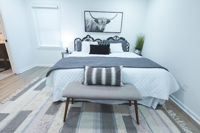 bedroom featuring wood finished floors and baseboards