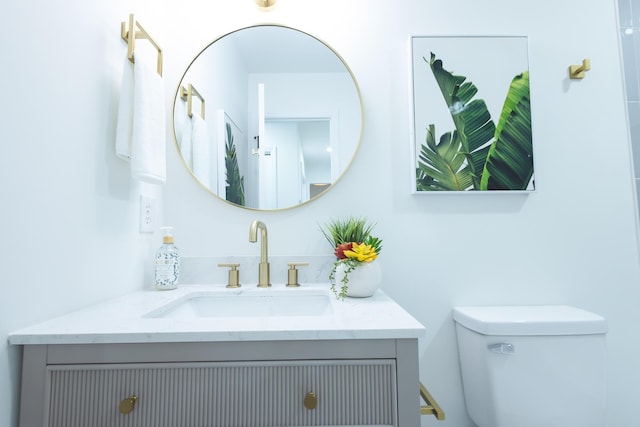 half bathroom with vanity and toilet