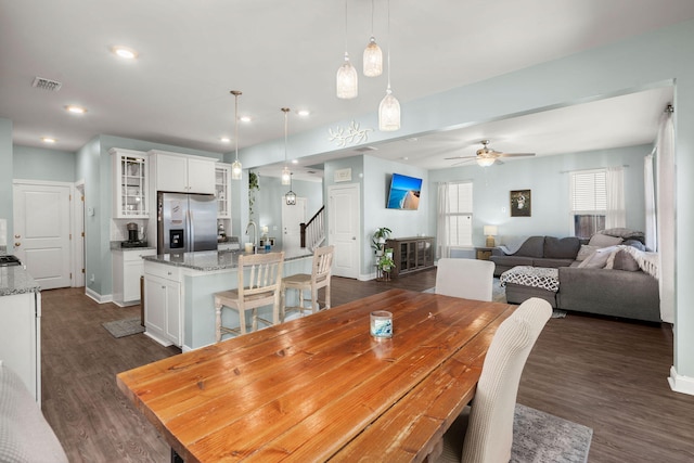 dining area featuring ceiling fan, sink, and dark hardwood / wood-style flooring