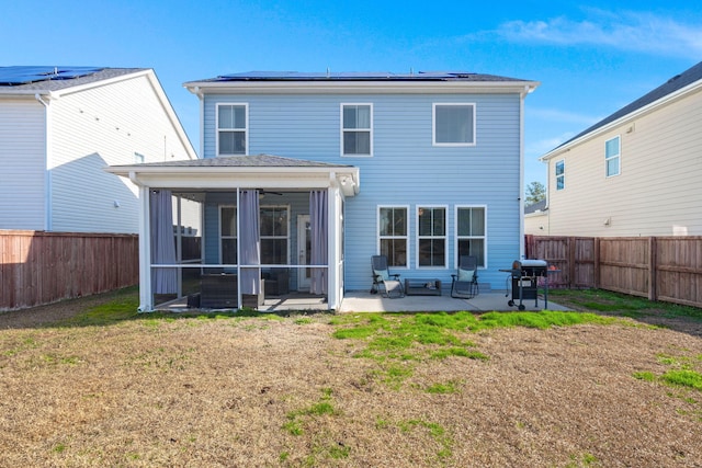 back of house with a patio area, solar panels, a yard, and a sunroom