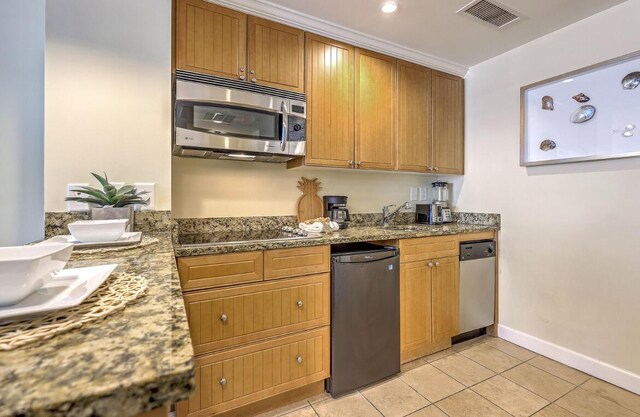 5802 Palmetto Dr Unit B 314, Isle Of Palms, SC 29451 - kitchen with stainless steel appliances, light tile patterned flooring, baseboards, and brown cabinetry