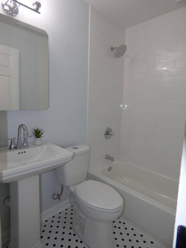 full bathroom featuring tile patterned flooring, tiled shower / bath combo, toilet, and sink