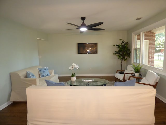 living room with ceiling fan and dark wood-type flooring