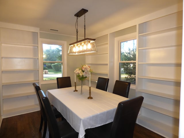 dining space with dark hardwood / wood-style flooring and a healthy amount of sunlight