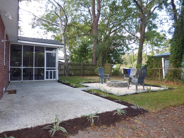 view of yard with a sunroom, a patio area, and an outdoor fire pit