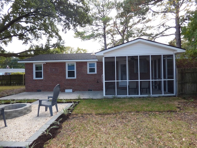 back of house featuring a patio, a fire pit, and a sunroom