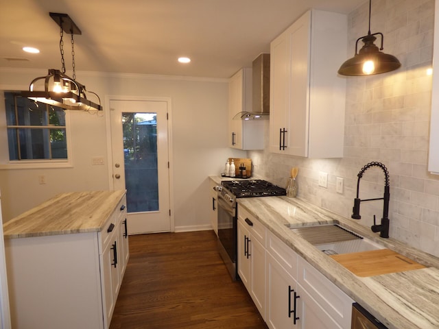 kitchen featuring wall chimney exhaust hood, stainless steel range with gas cooktop, pendant lighting, dark hardwood / wood-style floors, and white cabinetry