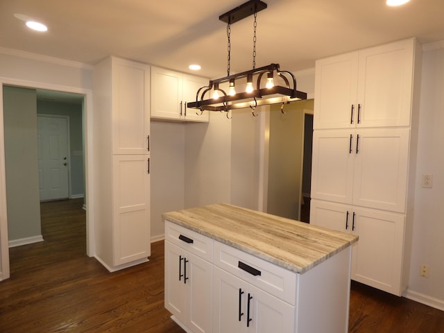 kitchen with decorative light fixtures, white cabinetry, dark wood-type flooring, and ornamental molding