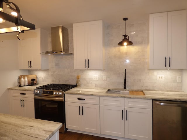 kitchen with white cabinets, wall chimney range hood, sink, and appliances with stainless steel finishes