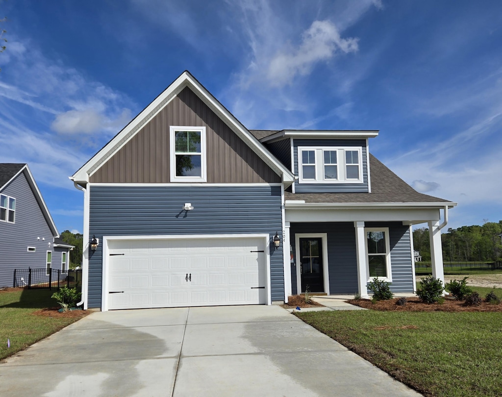 view of front of property with concrete driveway, board and batten siding, covered porch, an attached garage, and a front yard