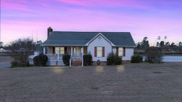 view of front of house featuring a porch, crawl space, and a chimney