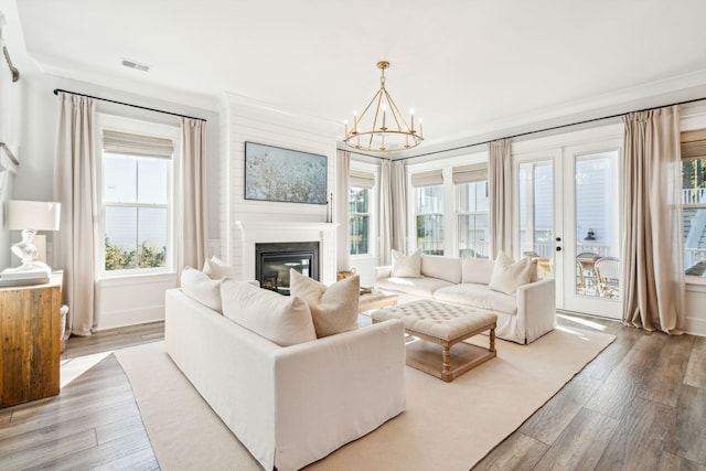 living room with ornamental molding, hardwood / wood-style flooring, and a healthy amount of sunlight